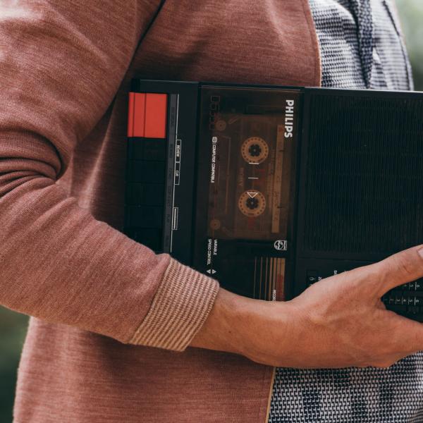 © Loïc Nys Quelqu'un dont on ne voit que le buste tient sur son bras un lecteur de cassettes portable Philips.