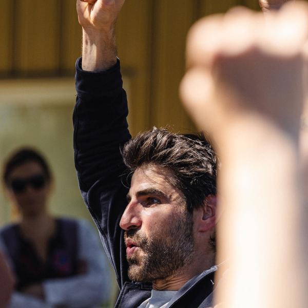 © Studio Pichet Les deux comédiens ont un poing levé. On voit les poings levés de la foule autour, flous.