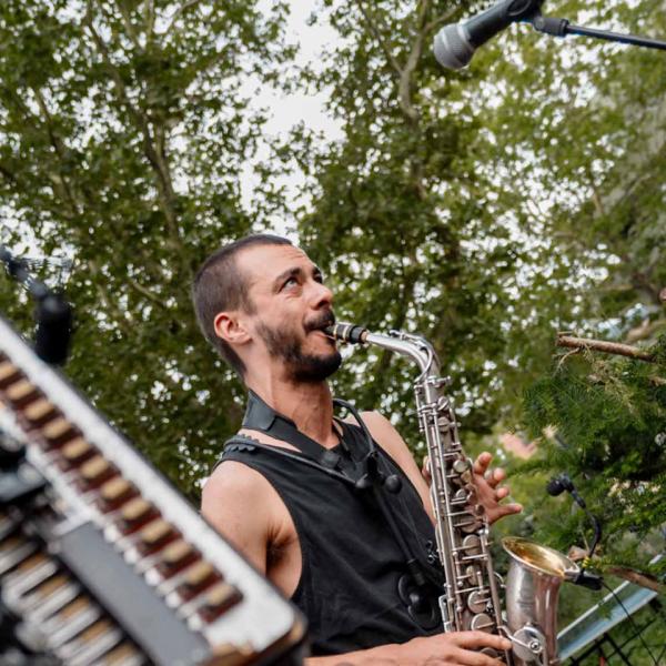 © Droits réservés Trois musiciens en extérieur ; un joue de l'accordéon, un joue du saxophone et le dernier du darbuka.