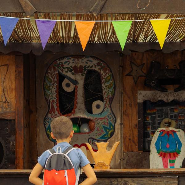 @ Solveig Augereau Une femme et un enfant, de dos, regardent le stand de tir, décoré de fanions.