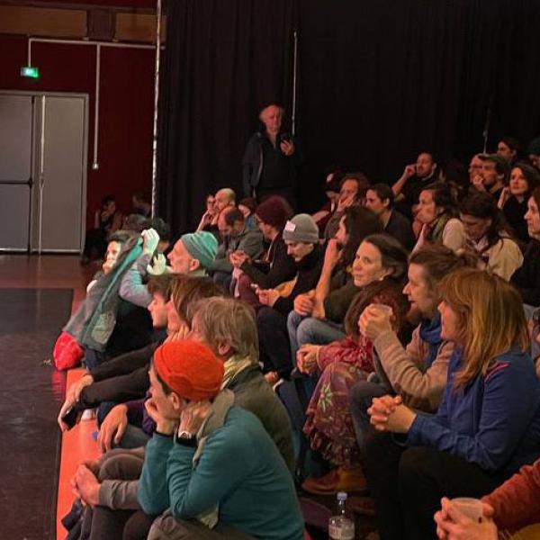 © Droits réservés Un homme se tient debout avec un micro dans la petite salle du Kiwi devant un public au complet.